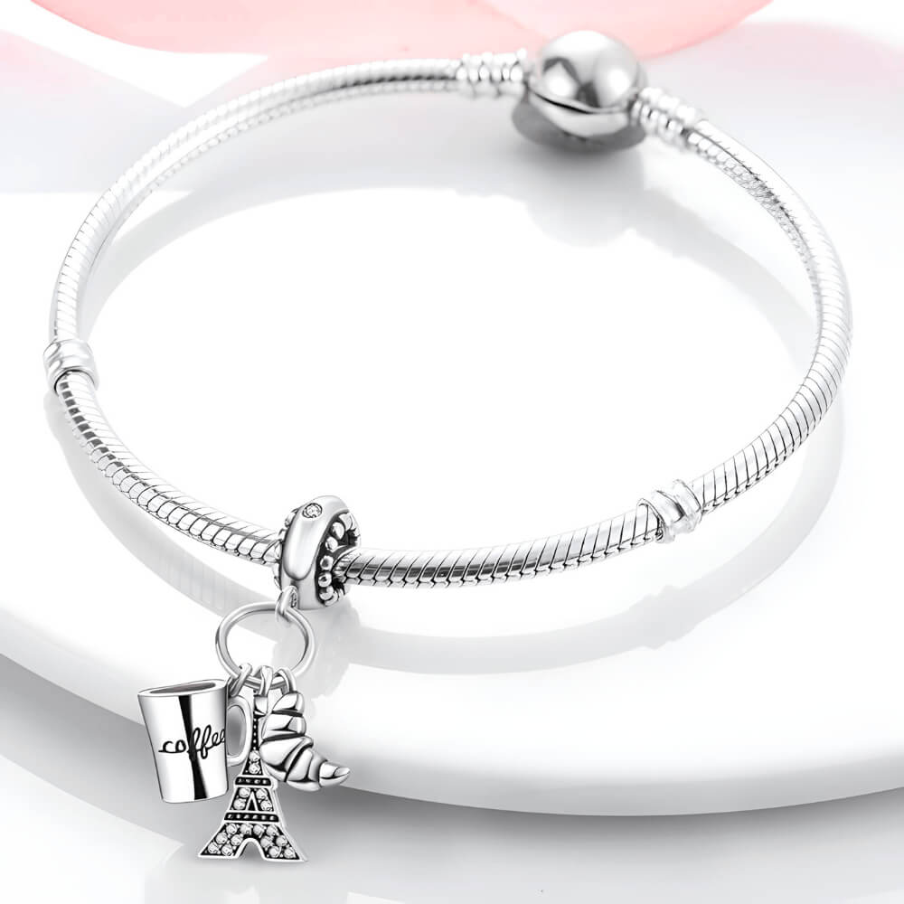 Sterling silver charm with three dangles: a coffee cup engraved with ‘coffee’, a croissant, and a crystal-studded Eiffel Tower