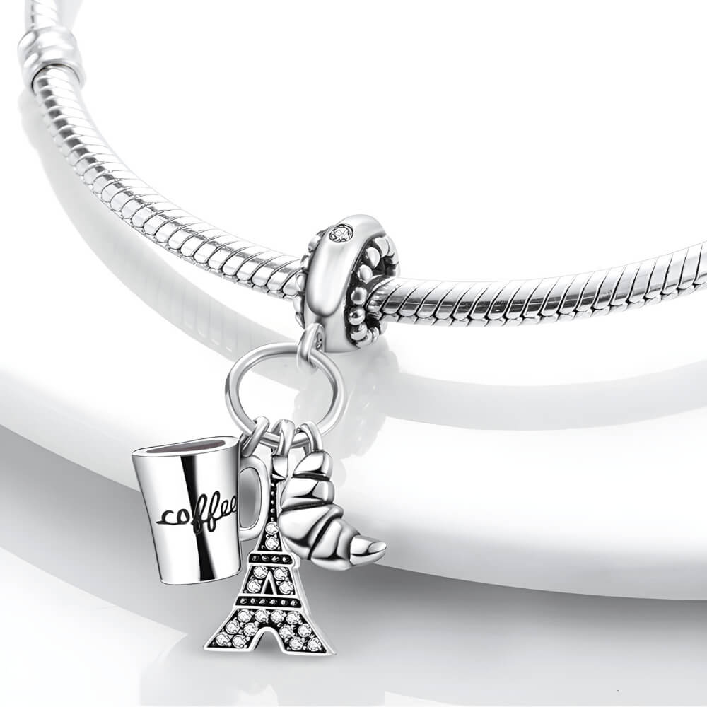 Sterling silver charm with three dangles: a coffee cup engraved with ‘coffee’, a croissant, and a crystal-studded Eiffel Tower