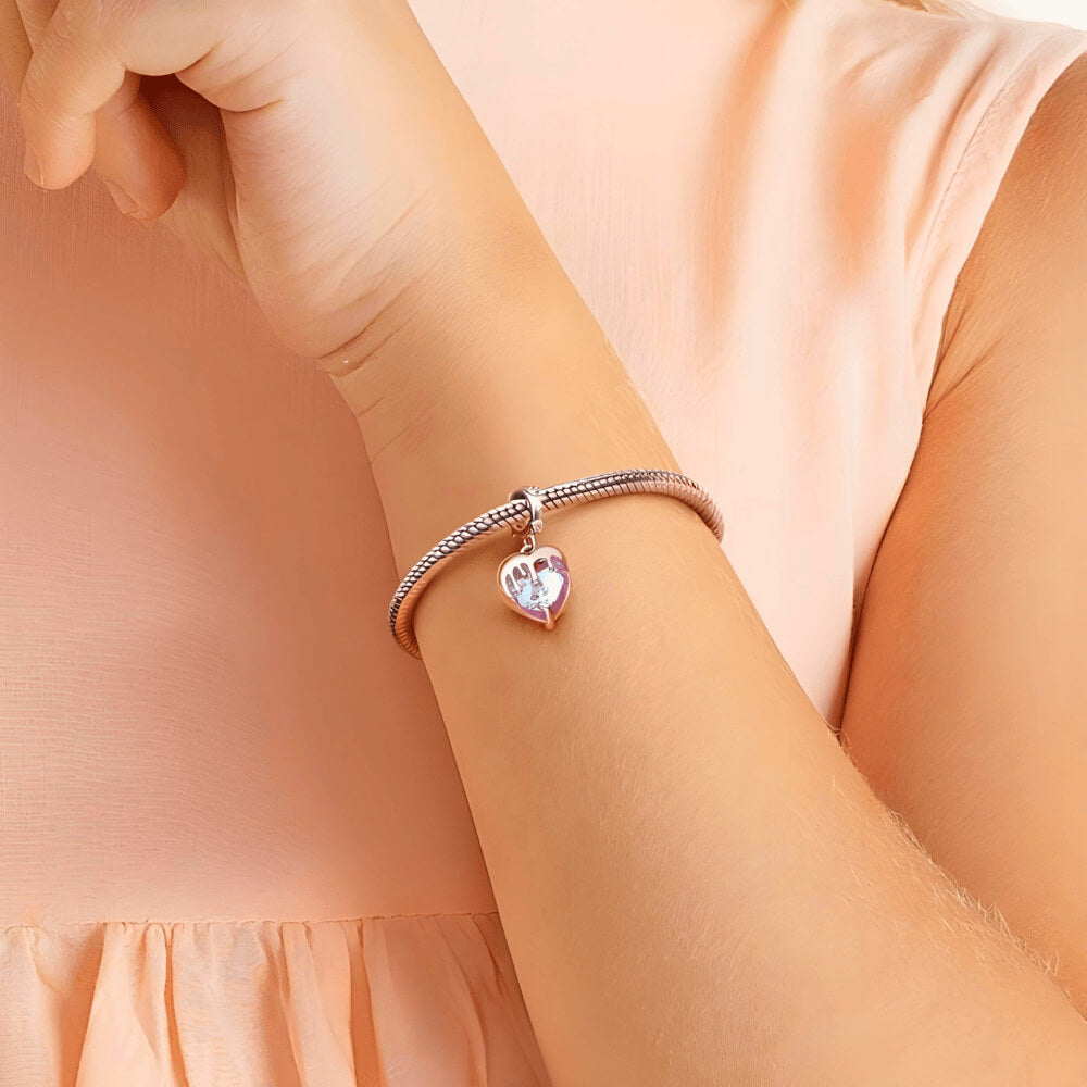 Sterling silver charm with a faceted pink heart crystal covered by a silver melting-drip design and a bail set with small clear stones
