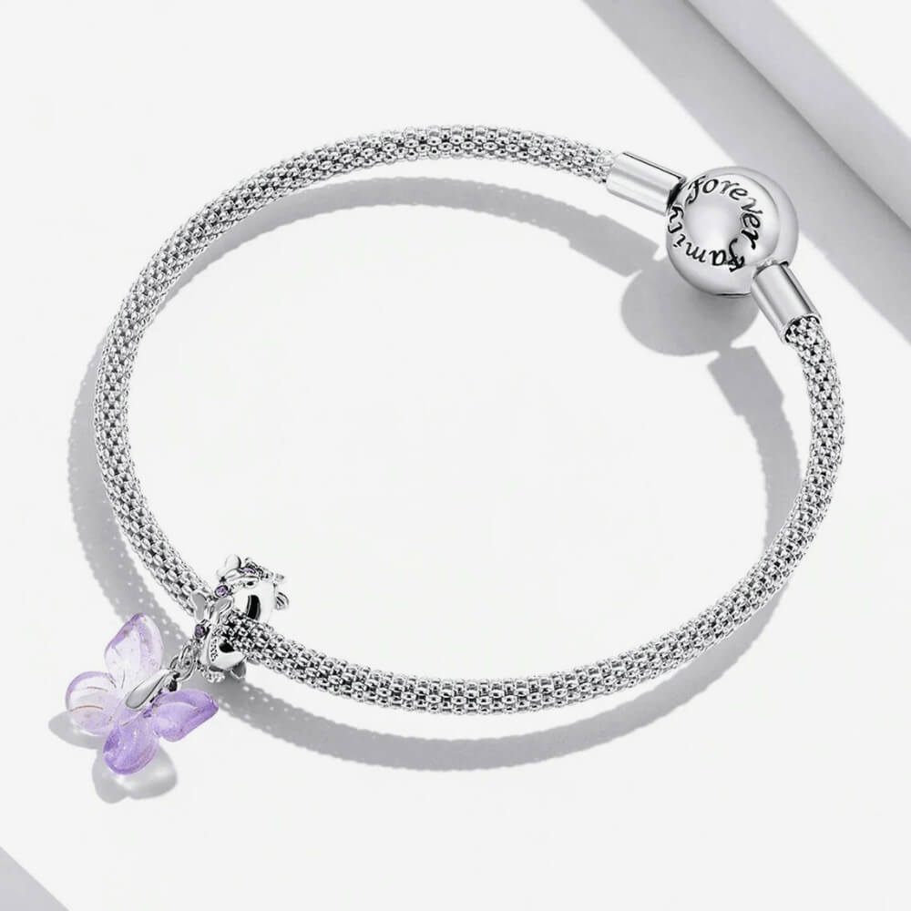 Sterling silver charm with a pale purple glass butterfly pendant and a butterfly-shaped bail decorated with small purple stones