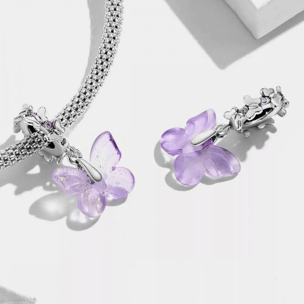 Sterling silver charm with a pale purple glass butterfly pendant and a butterfly-shaped bail decorated with small purple stones
