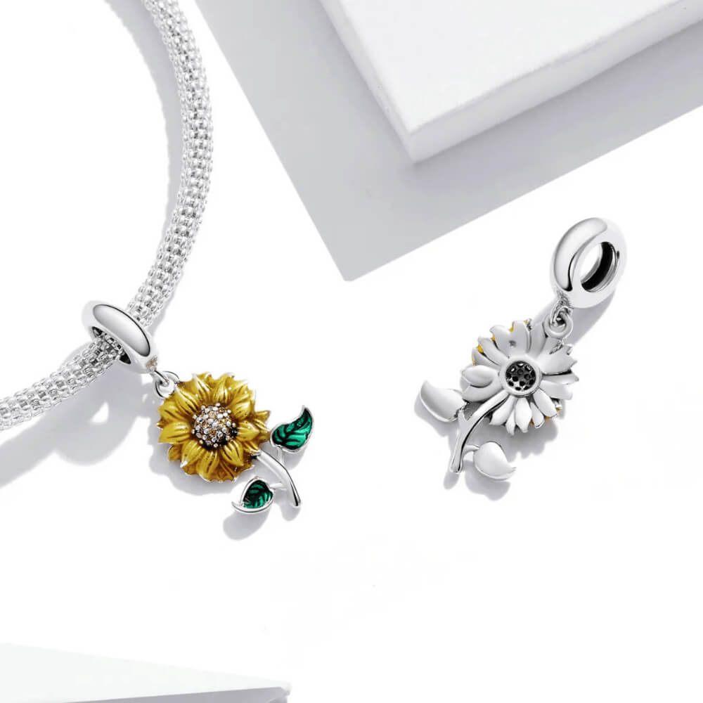 Sterling silver sunflower charm with yellow enamel petals, a crystal-studded center, and two green enamel leaves