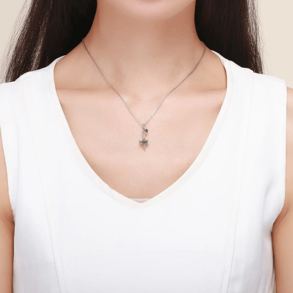 Sterling silver charm with a flower-shaped umbrella design, teal enamel petals, and two dangling blue crystals 