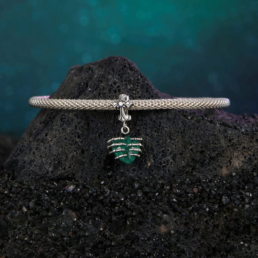 Sterling silver skeleton heart charm with emerald crystal and gothic details.