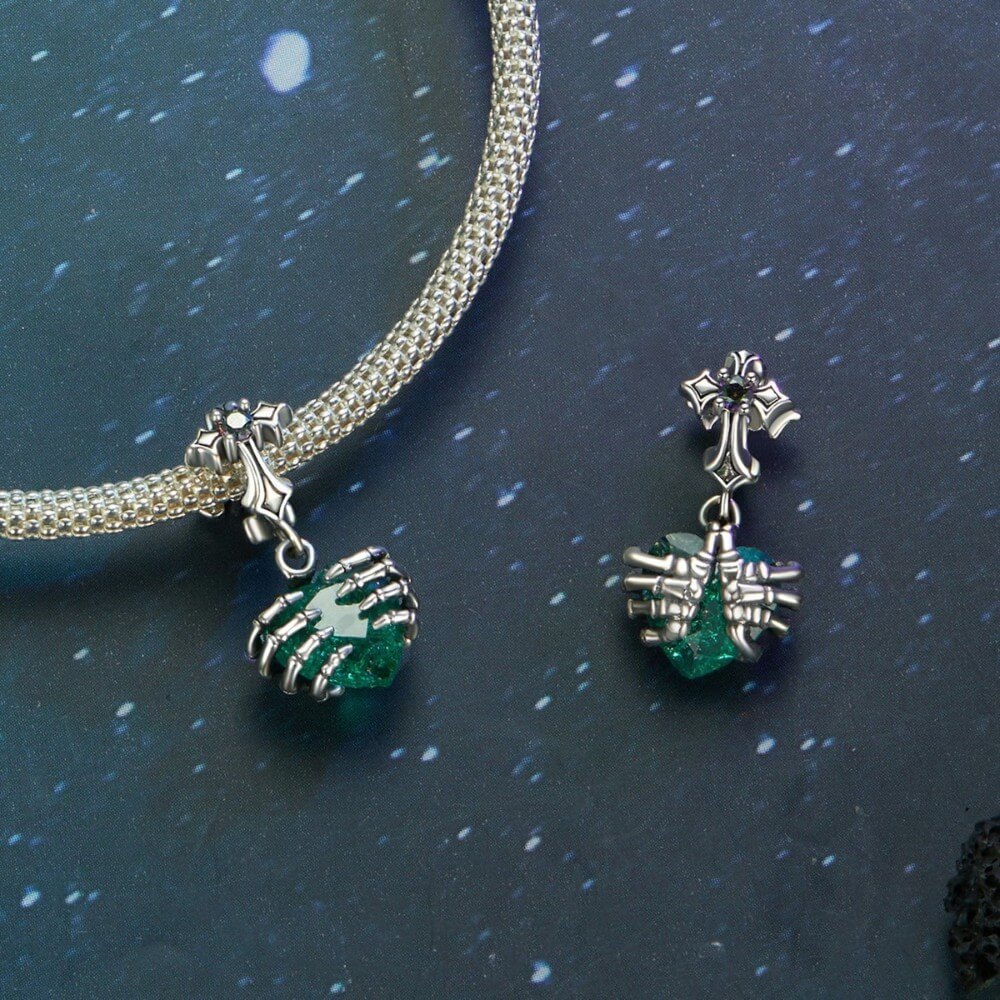 Sterling silver skeleton heart charm with emerald crystal and gothic details.