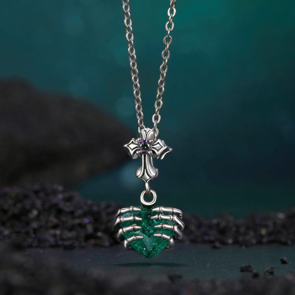 Sterling silver skeleton heart charm with emerald crystal and gothic details.
