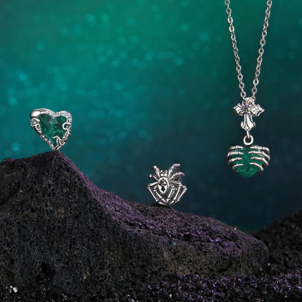 Sterling silver skeleton heart charm with emerald crystal and gothic details.
