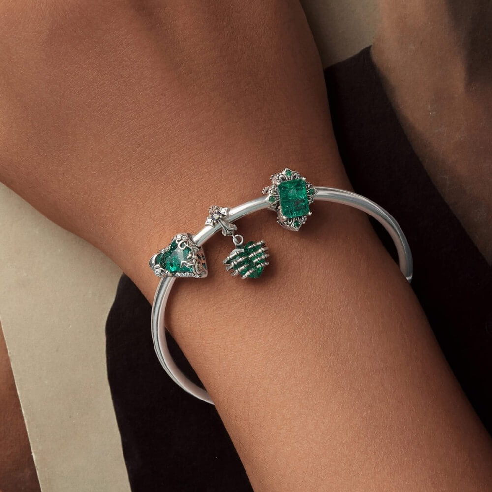 Sterling silver skeleton heart charm with emerald crystal and gothic details.