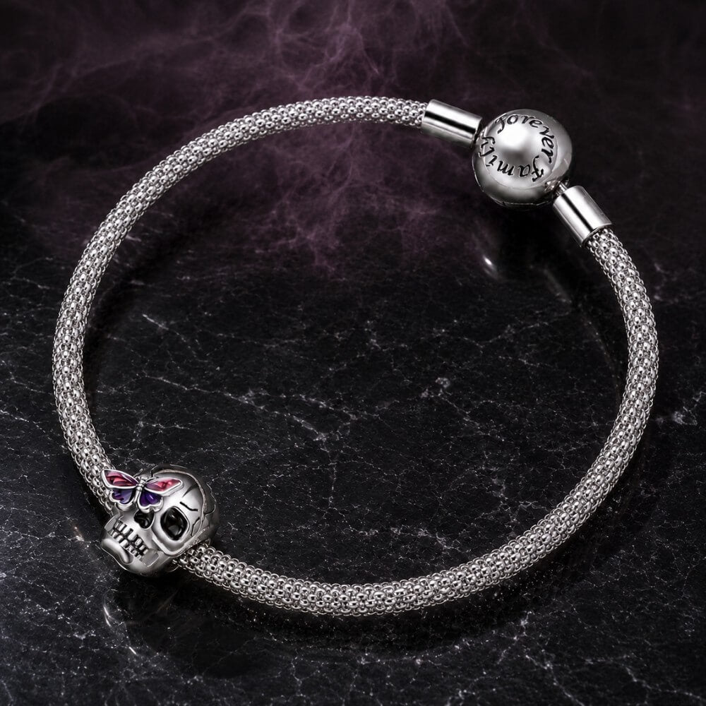 Sterling silver skull charm with purple butterfly and black enamel details.