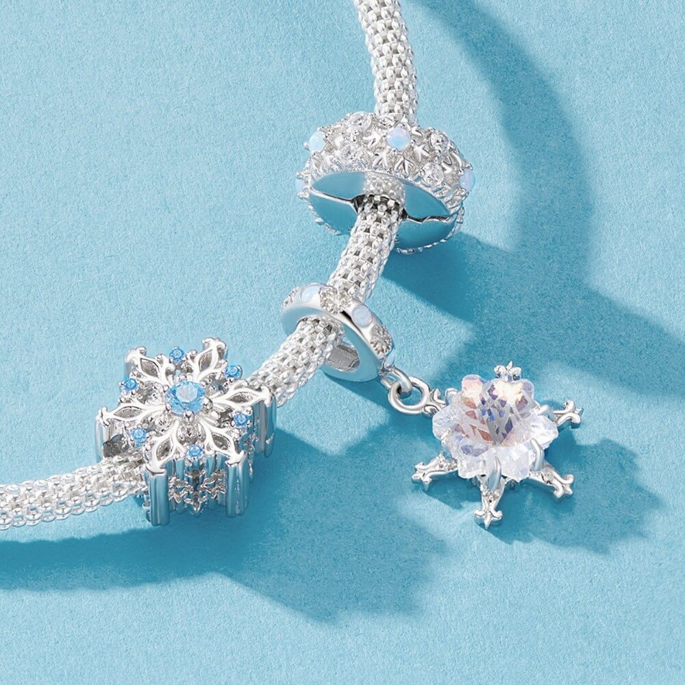 Sterling silver snowflake charm with iridescent crystal and blue accents.