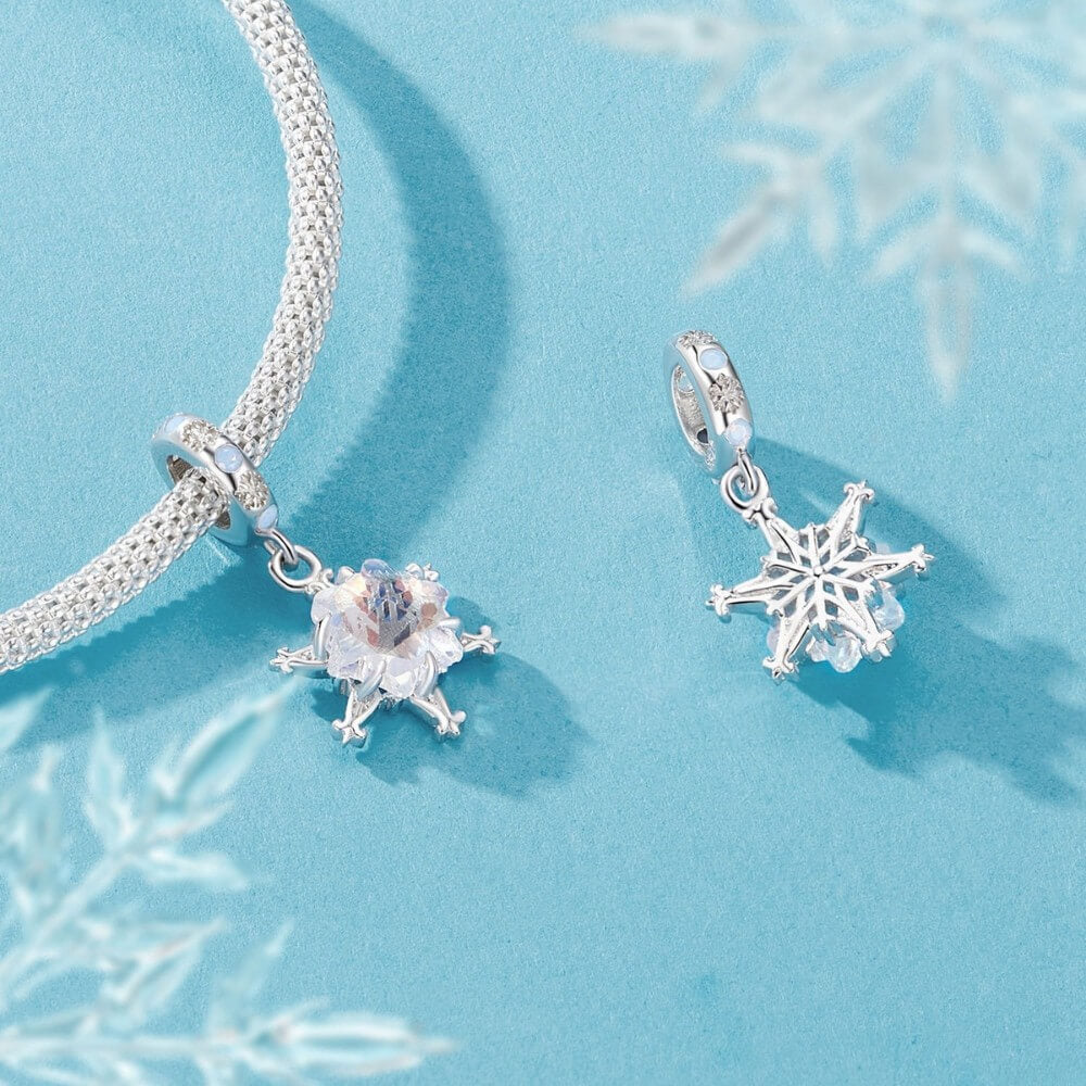 Sterling silver snowflake charm with iridescent crystal and blue accents.