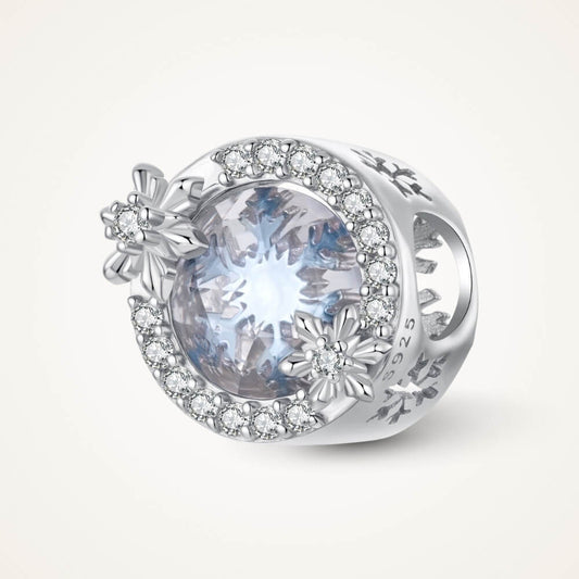 Sterling silver snowflake charm with icy crystal center and pavé details.