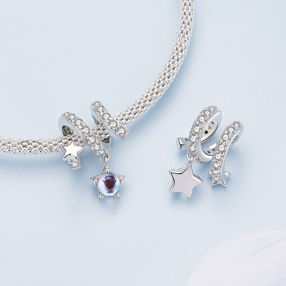 Sterling silver swirl charm with star details and iridescent dangling crystal.
