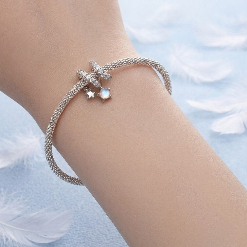 Sterling silver swirl charm with star details and iridescent dangling crystal.