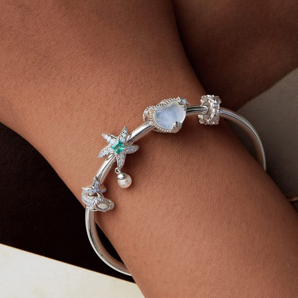 Sterling silver starfish charm with green crystal, opal stones, and pearl.
