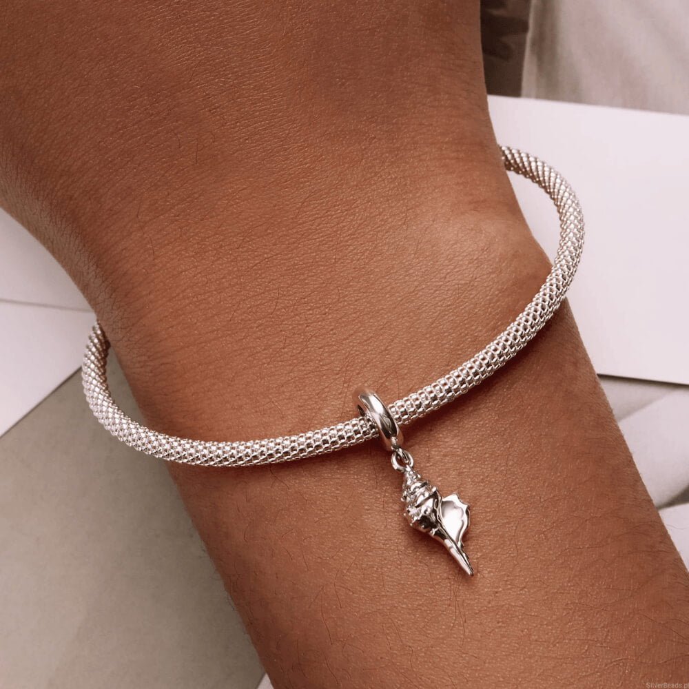Sterling silver seashell dangle charm featuring a detailed conch shell design and smooth polished bail 