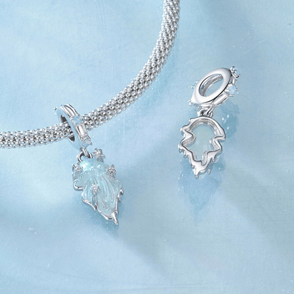 Sterling silver jellyfish dangle charm with iridescent enamel body, flowing tentacle design, and small clear gemstones on the bail and charm 