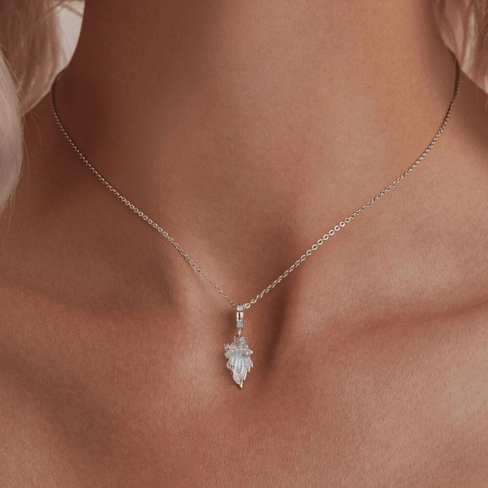 Sterling silver jellyfish dangle charm with iridescent enamel body, flowing tentacle design, and small clear gemstones on the bail and charm