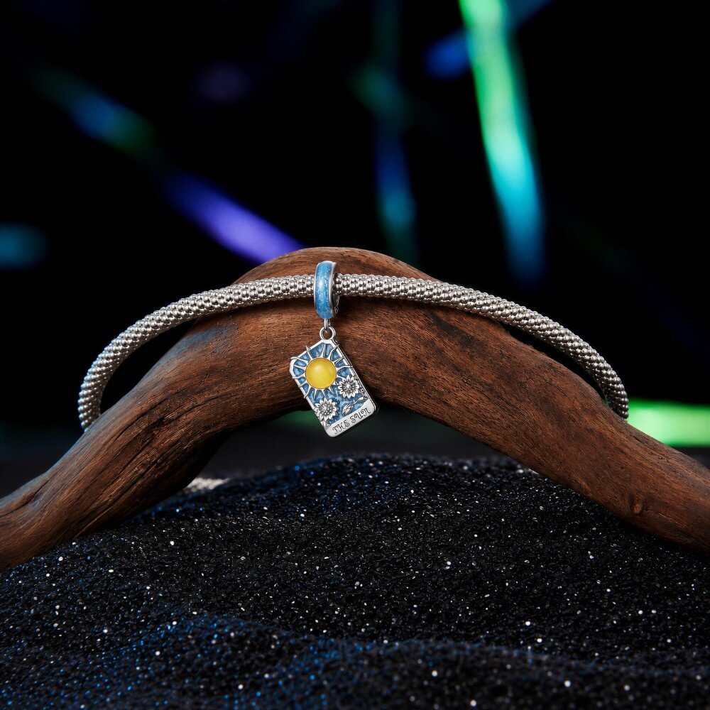 Sterling silver sun tarot charm with blue enamel and sunflower details.