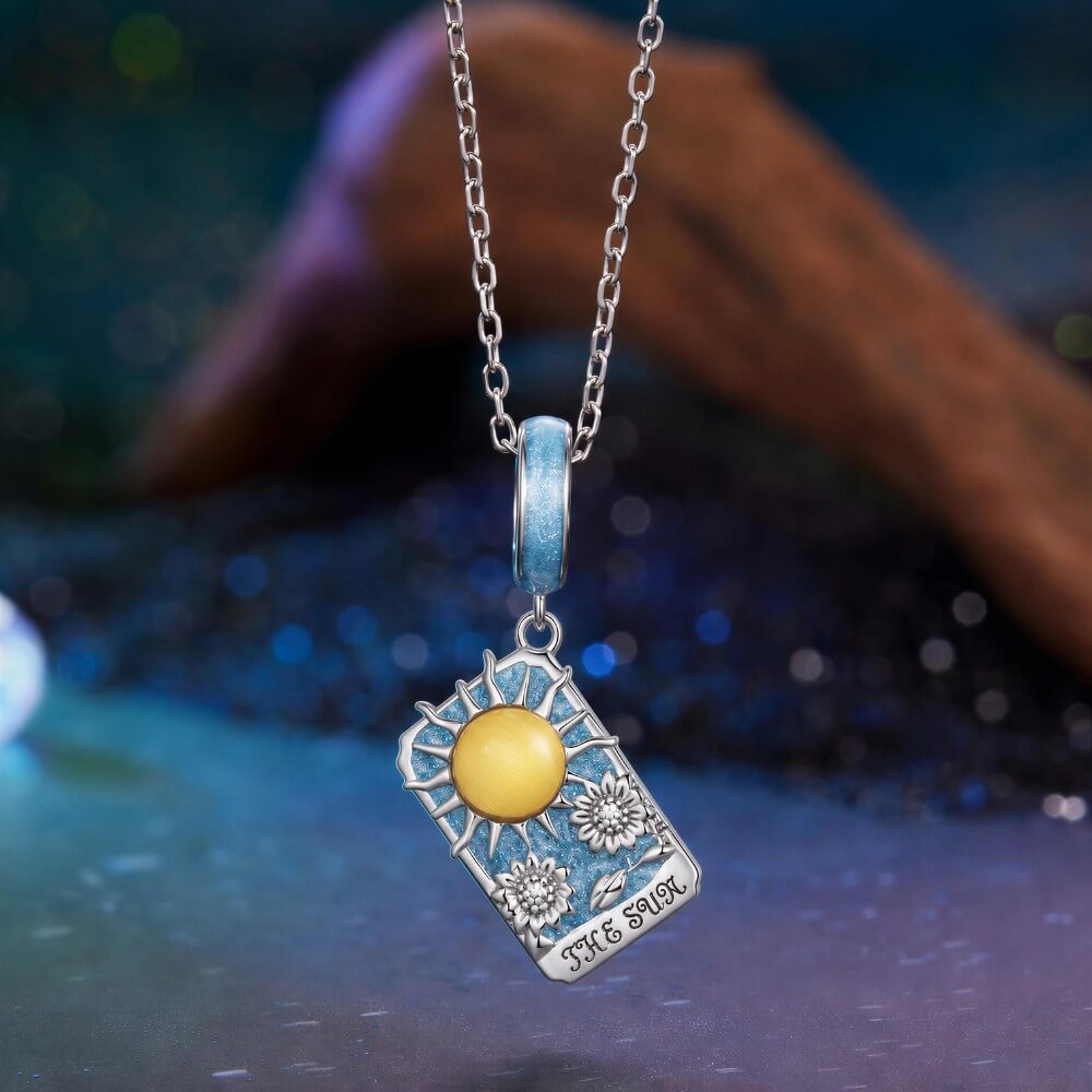 Sterling silver sun tarot charm with blue enamel and sunflower details.