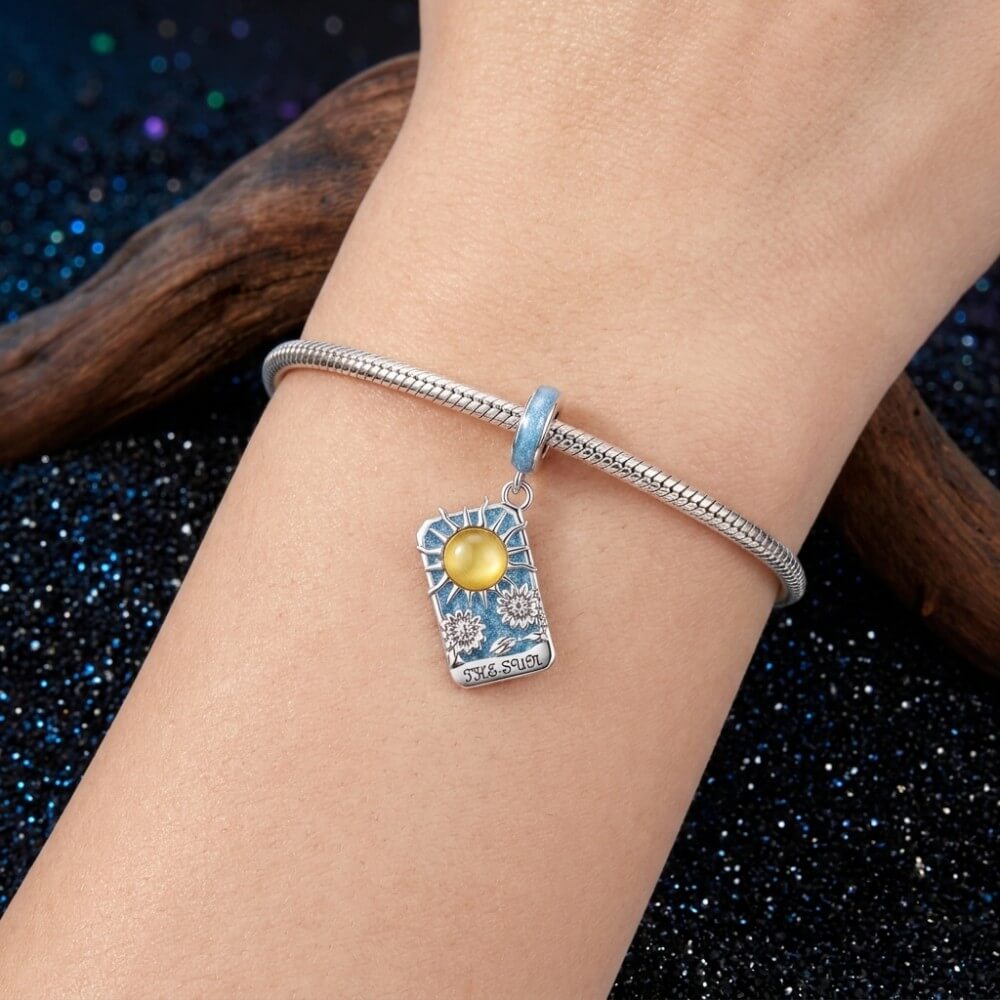 Sterling silver sun tarot charm with blue enamel and sunflower details.