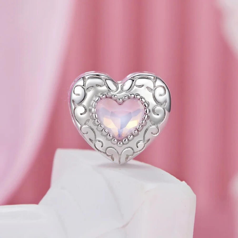 Sterling silver swan heart charm with pink crystal and pavé border.