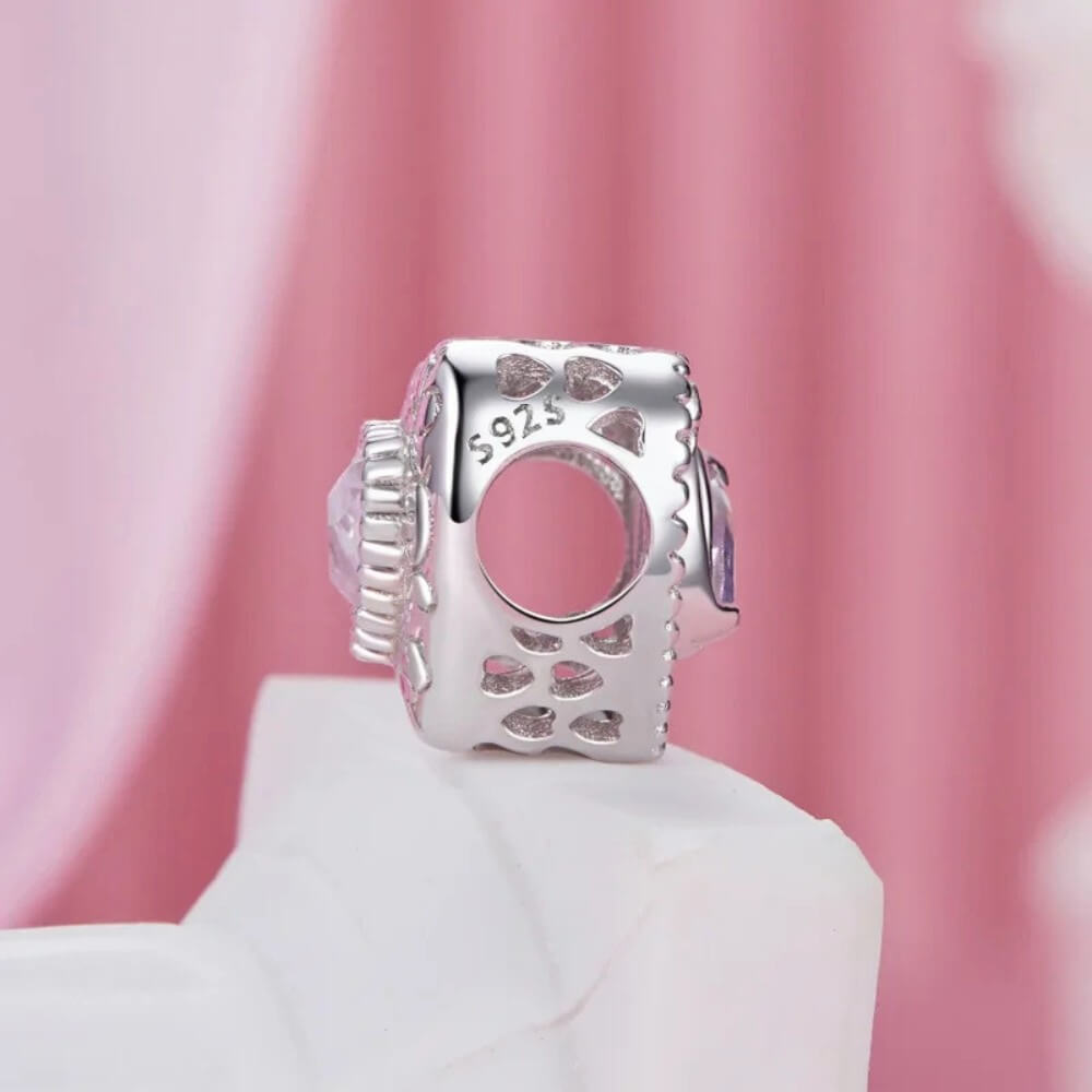 Sterling silver swan heart charm with pink crystal and pavé border.