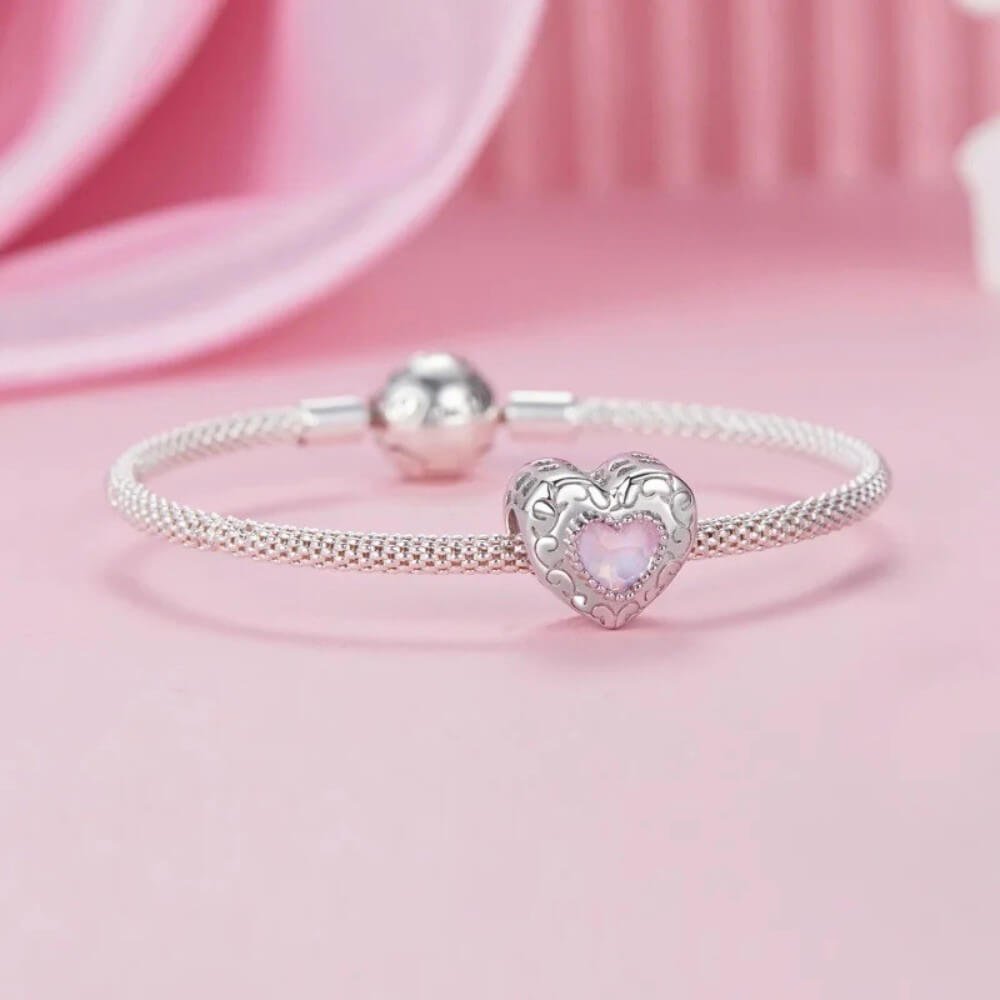 Sterling silver swan heart charm with pink crystal and pavé border.