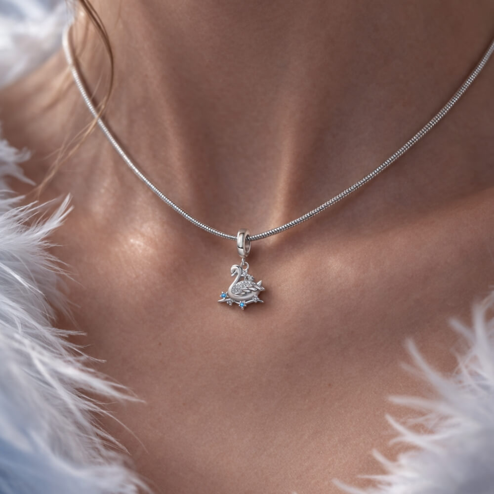 Sterling silver swan charm with crystal wings and star accents.