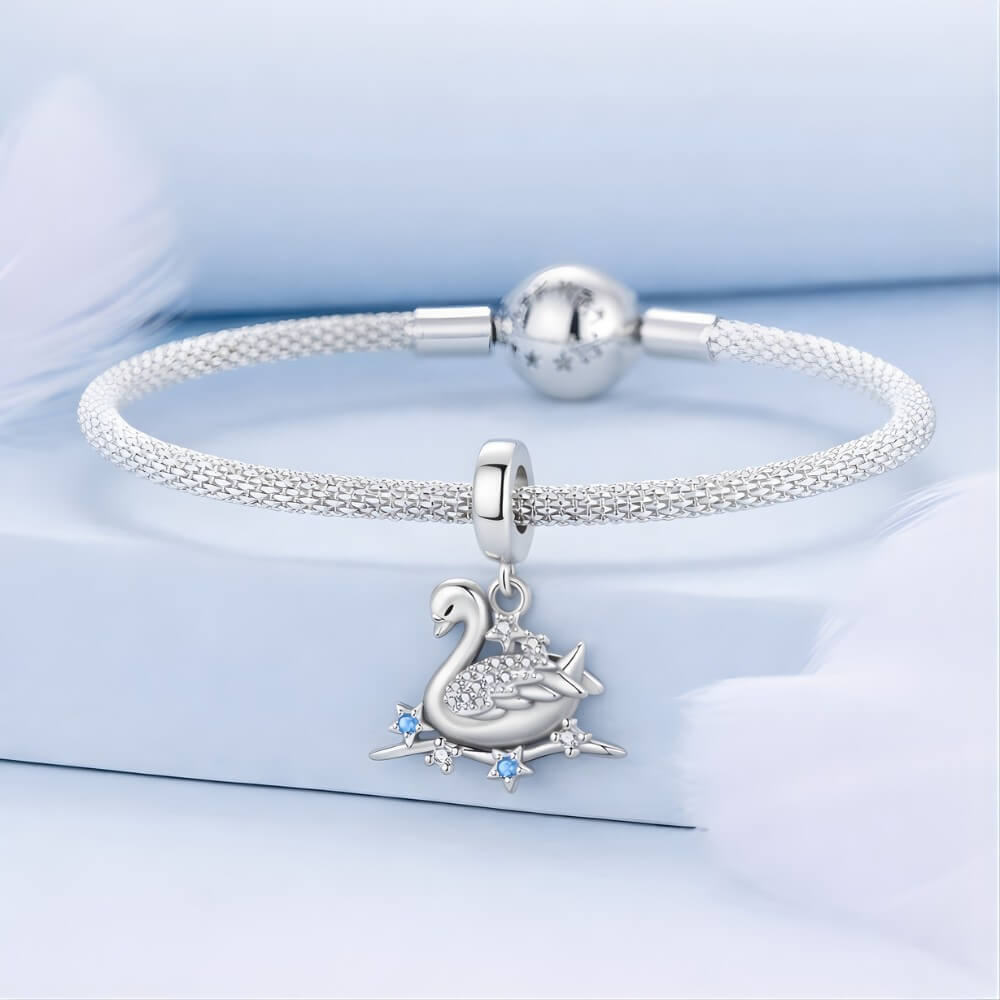Sterling silver swan charm with crystal wings and star accents.