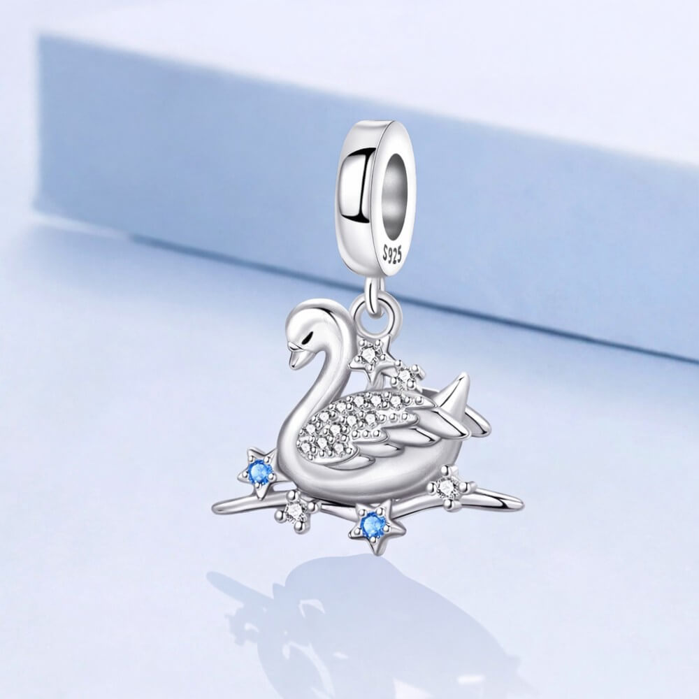 Sterling silver swan charm with crystal wings and star accents.