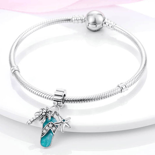 Sterling silver flip-flop charm with teal enamel, palm tree, starfish, and gemstones.