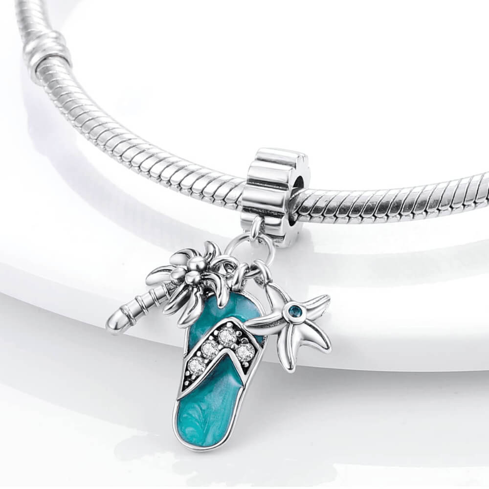 Sterling silver flip-flop charm with teal enamel, palm tree, starfish, and gemstones.