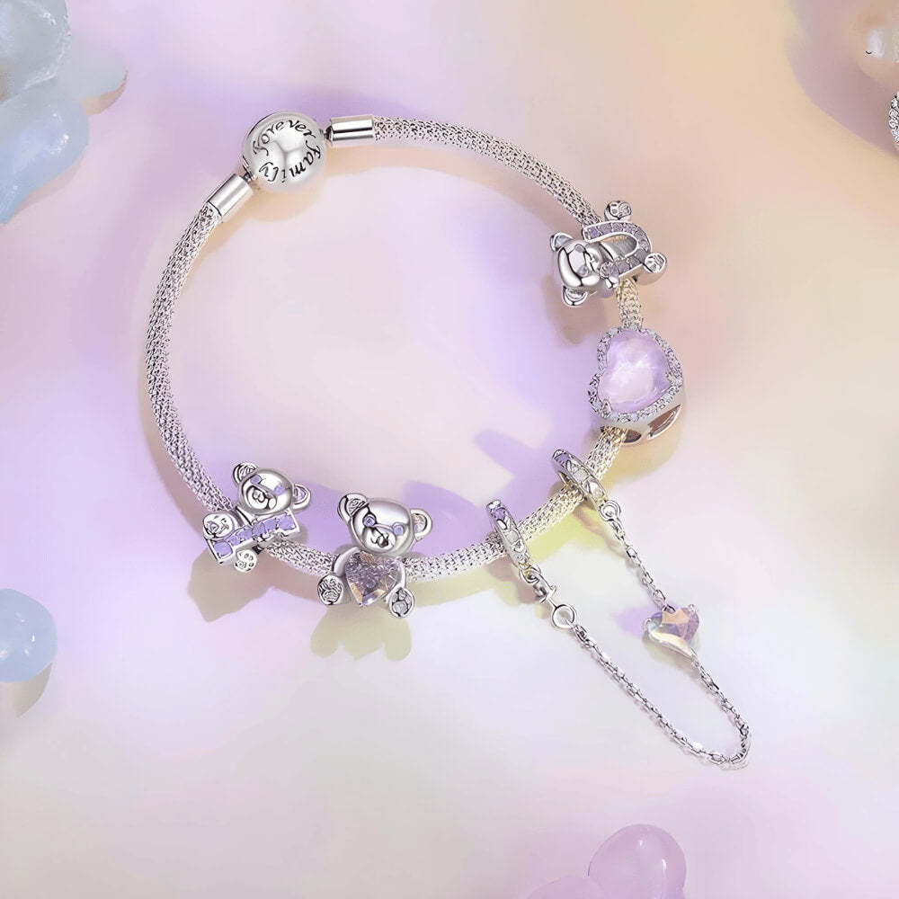 Sterling silver teddy bear charm holding an iridescent heart-shaped crystal with paw-print feet 