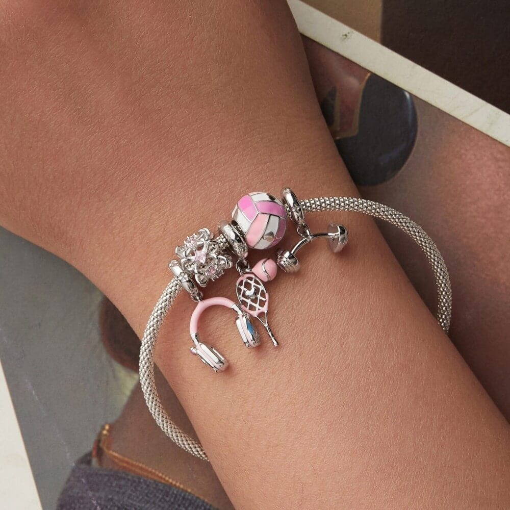 Sterling silver tennis racket charm with pink enamel ball.