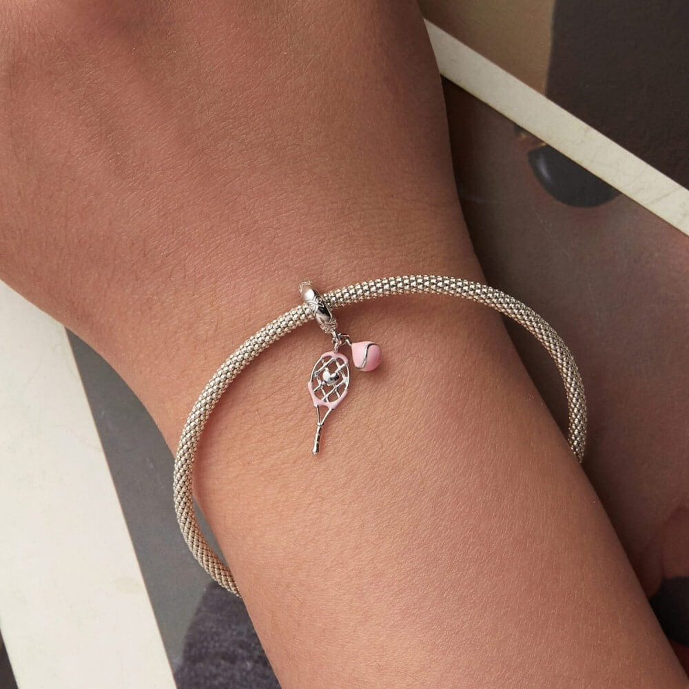 Sterling silver tennis racket charm with pink enamel ball.