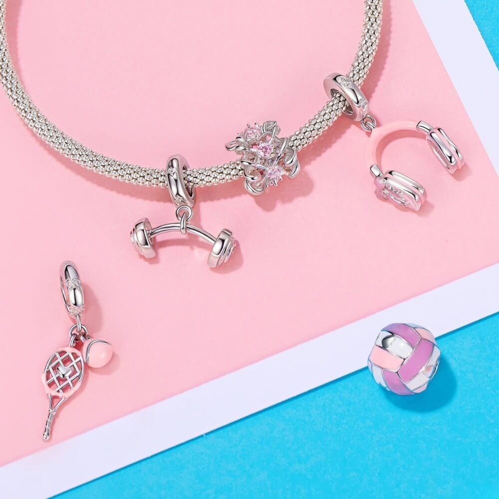 Sterling silver tennis racket charm with pink enamel ball.