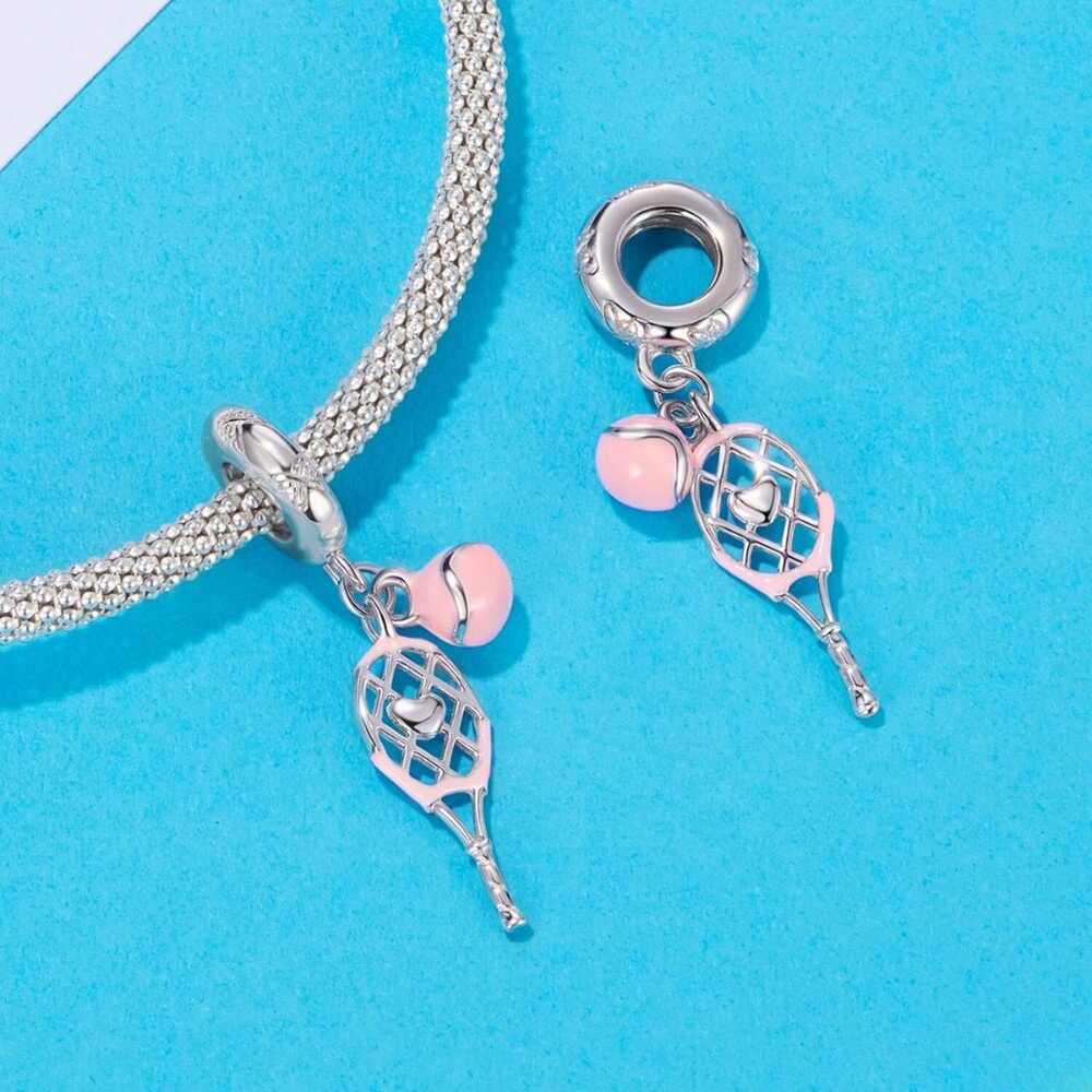 Sterling silver tennis racket charm with pink enamel ball.