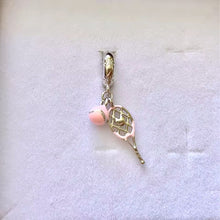 Sterling silver tennis racket charm with pink enamel ball.