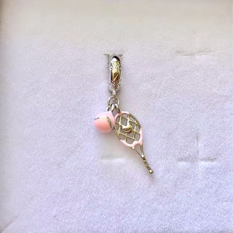 Sterling silver tennis racket charm with pink enamel ball.