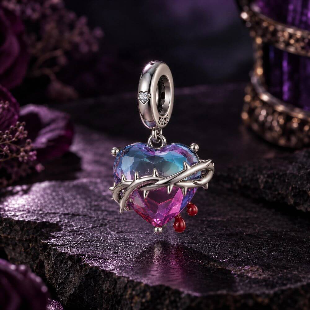 Sterling silver heart charm with blue pink crystal, thorned vine detail, and red drop accents.