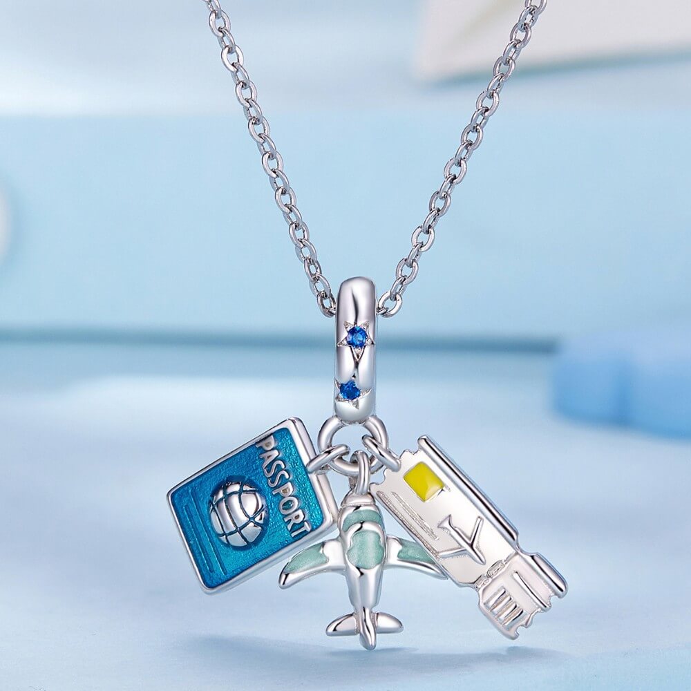 Sterling silver travel charm with passport, airplane, and ticket details.