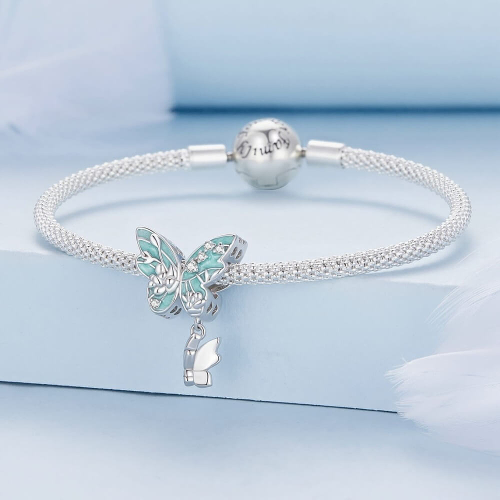 Silver bracelet with butterfly charm on a light blue background