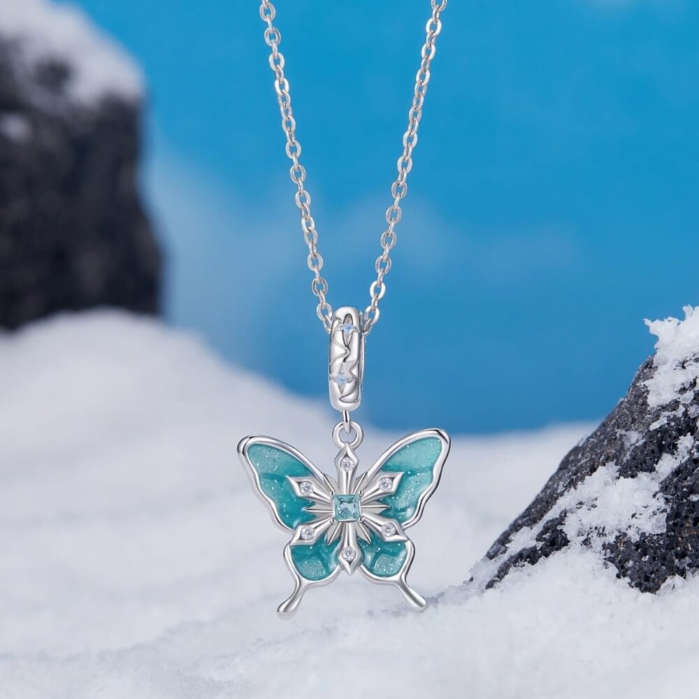 Sterling silver butterfly charm with turquoise enamel and crystal snowflake details.