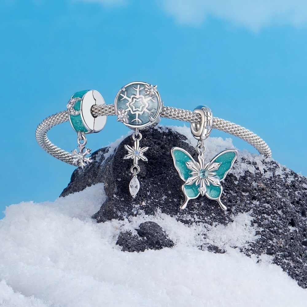 Sterling silver butterfly charm with turquoise enamel and crystal snowflake details.