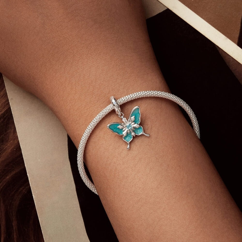 Sterling silver butterfly charm with turquoise enamel and crystal snowflake details.