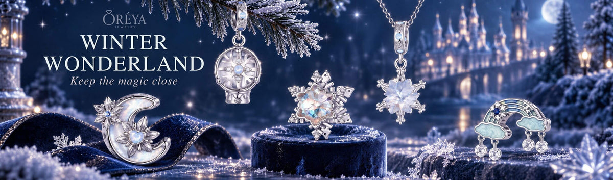 Winter-inspired Winter Wonderland ORÉYA silver charm collection with snowflakes, moon, blue crystals, and icy celestial designs.