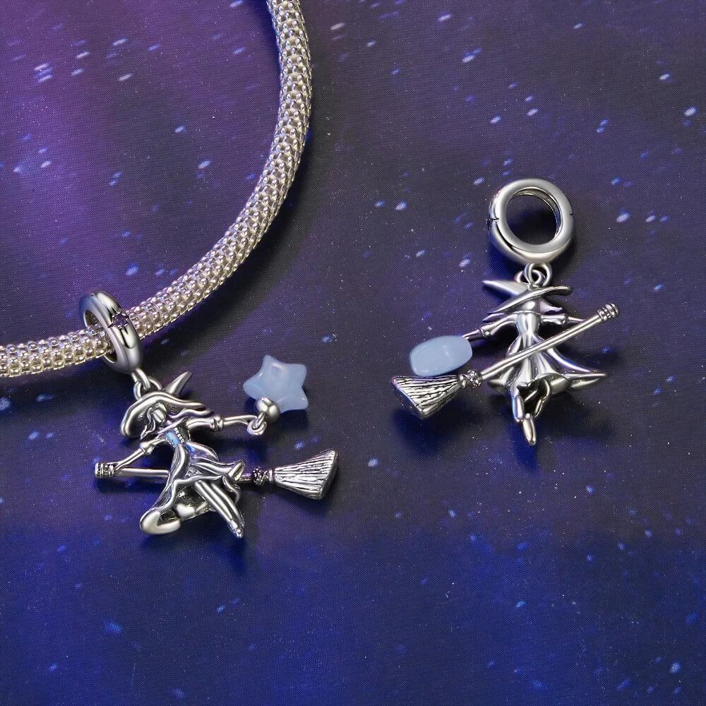 Sterling silver witch charm with broomstick, flowing dress, purple crystal, and glowing blue star lantern.