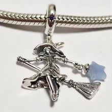 Sterling silver witch charm with broomstick, flowing dress, purple crystal, and glowing blue star lantern.