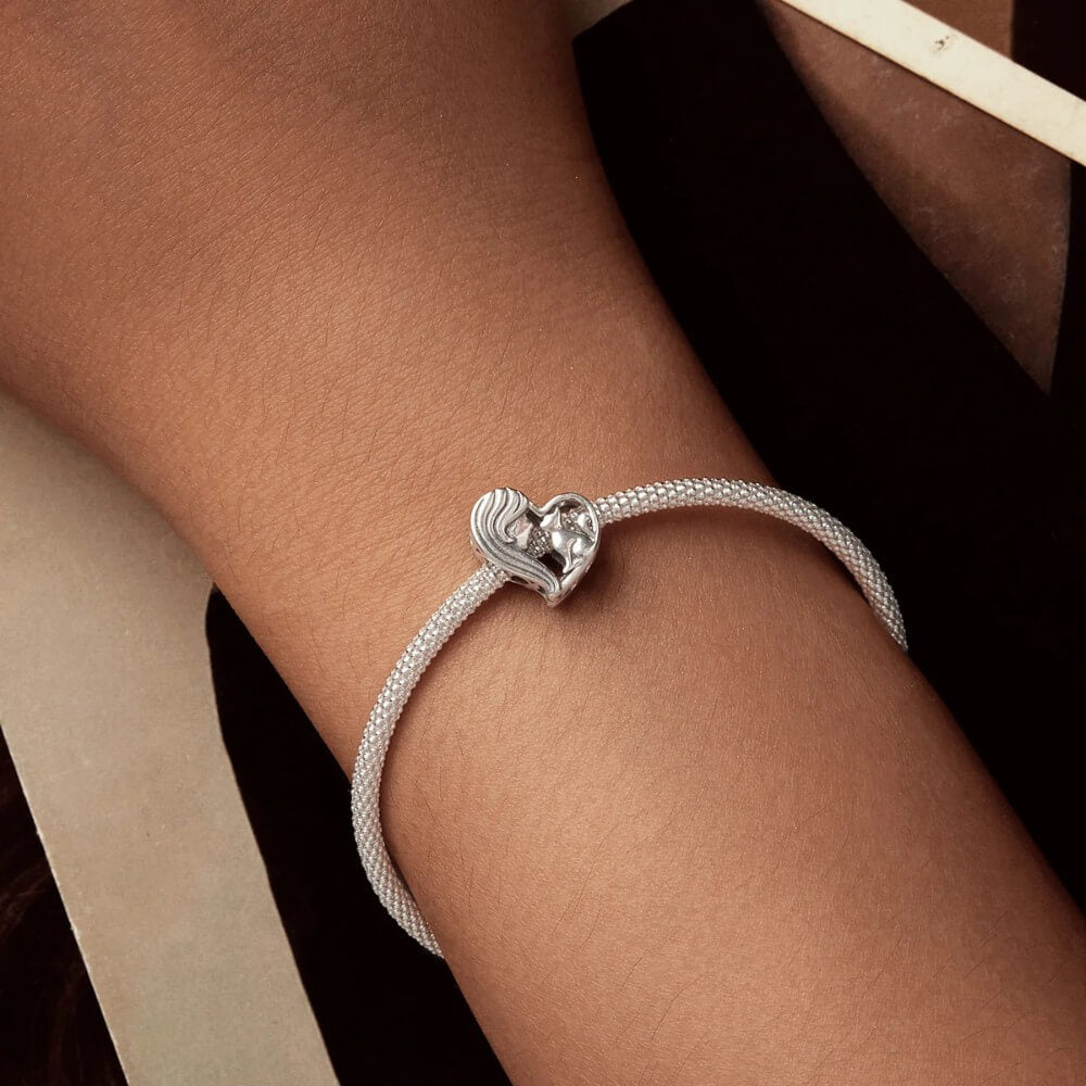 Sterling silver heart charm with woman and cat silhouette.